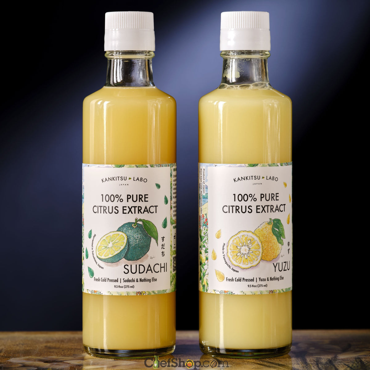Two bottles of 100% Pure Citrus Extract, one labeled Sudachi and the other Yuzu, on a wooden surface with a dark background.
