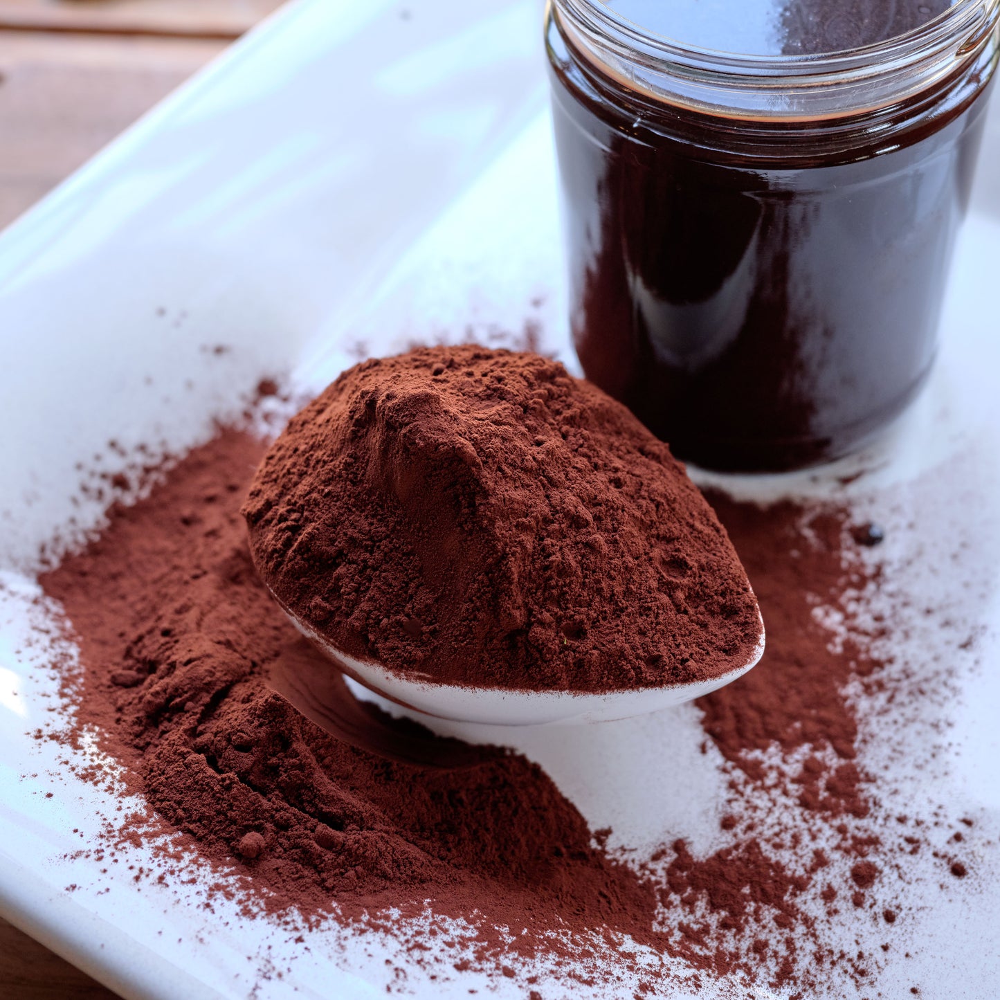 Cocoa powder with a spoon and jar on a white plate -ChefShop Grande Brut Cocoa Powder