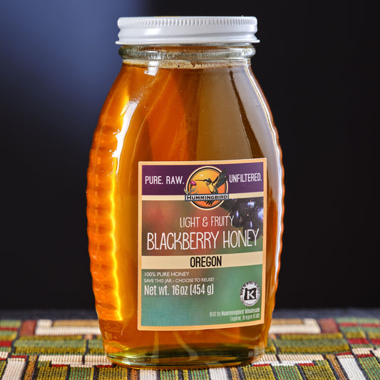 Jar of Hummingbird blackberry honey with a label on a colorful Frank Lloyd Wright placemat background