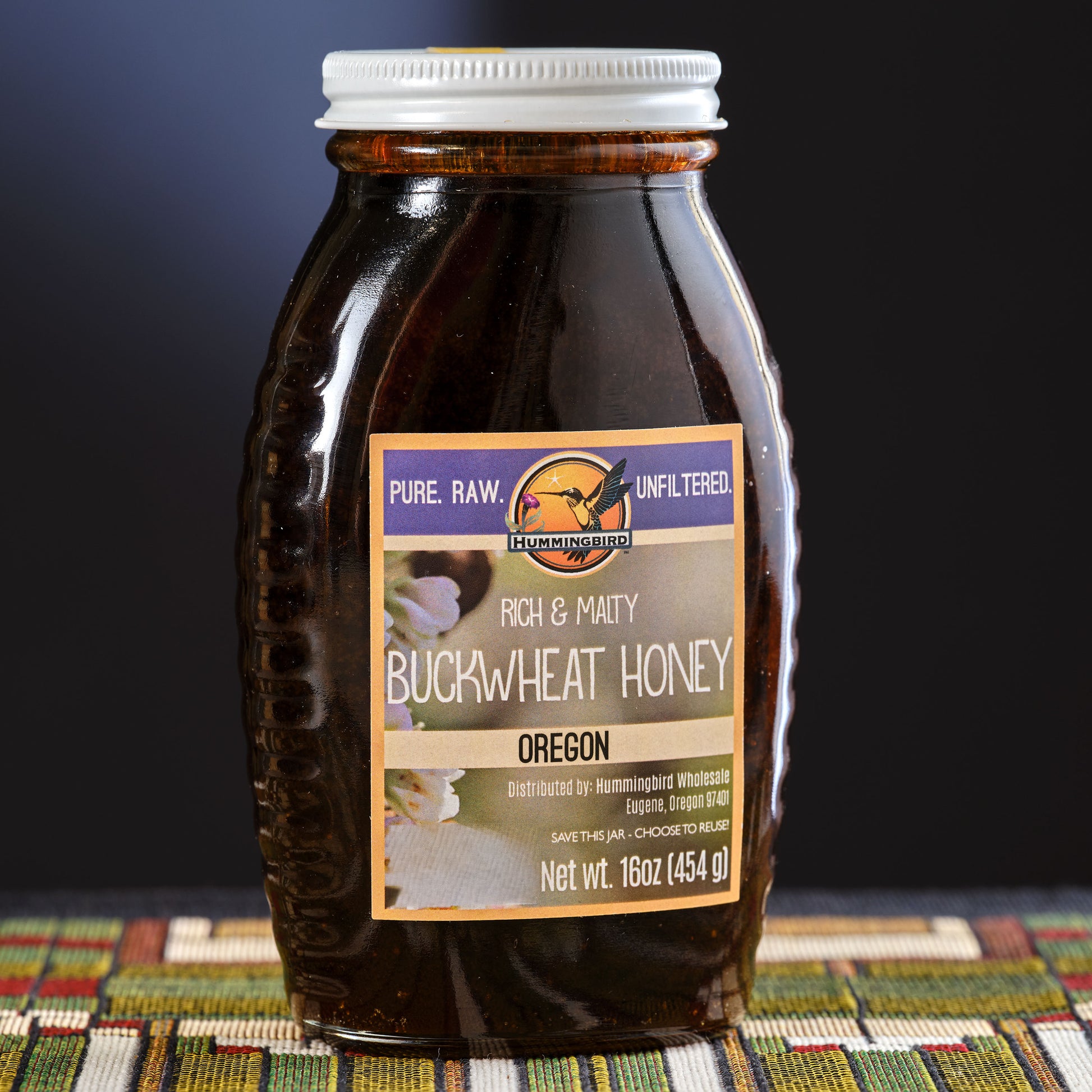Jar of buckwheat honey with a label on a patterned surface