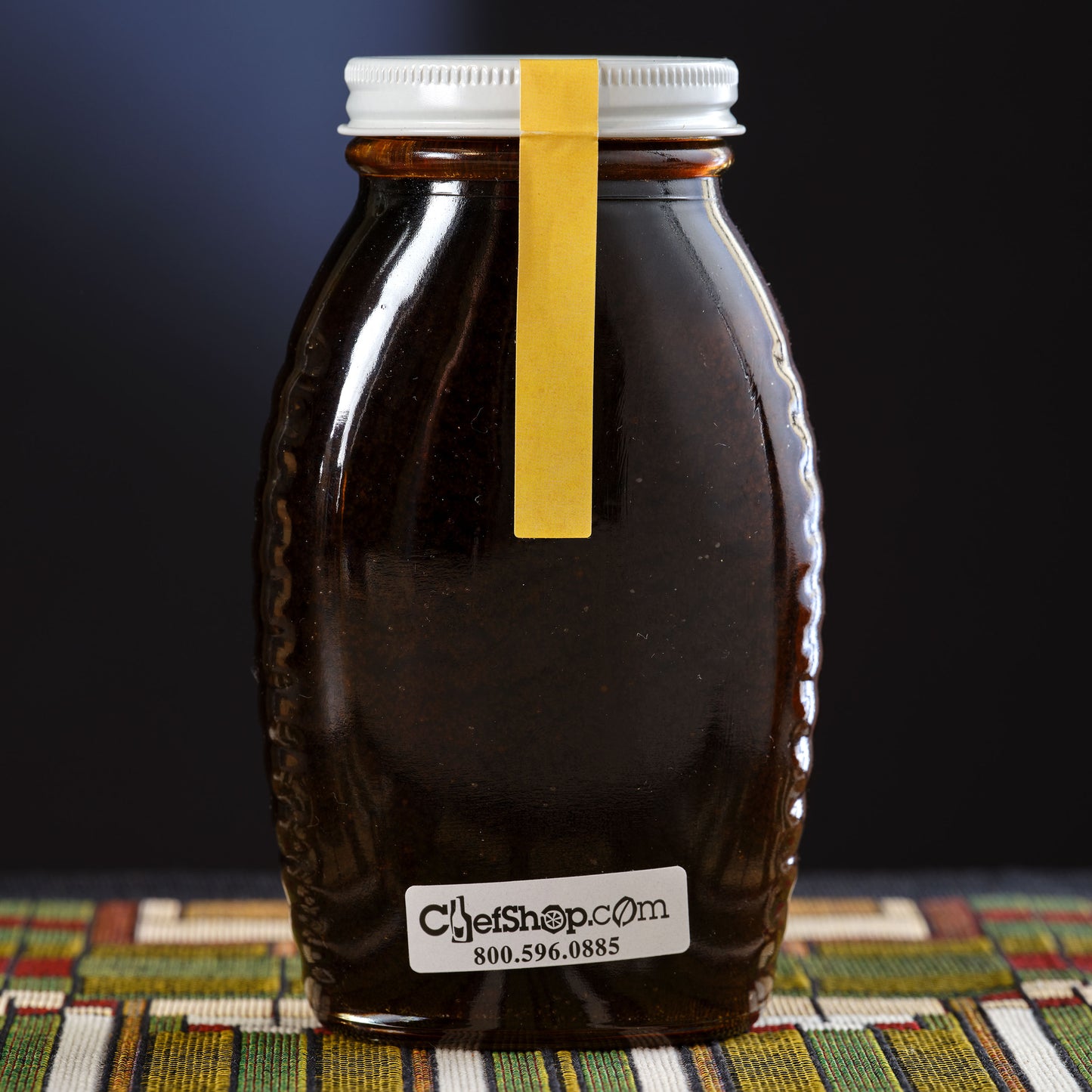 Bottle of honey with a yellow tape on a Frank Lloyd Wright  design
