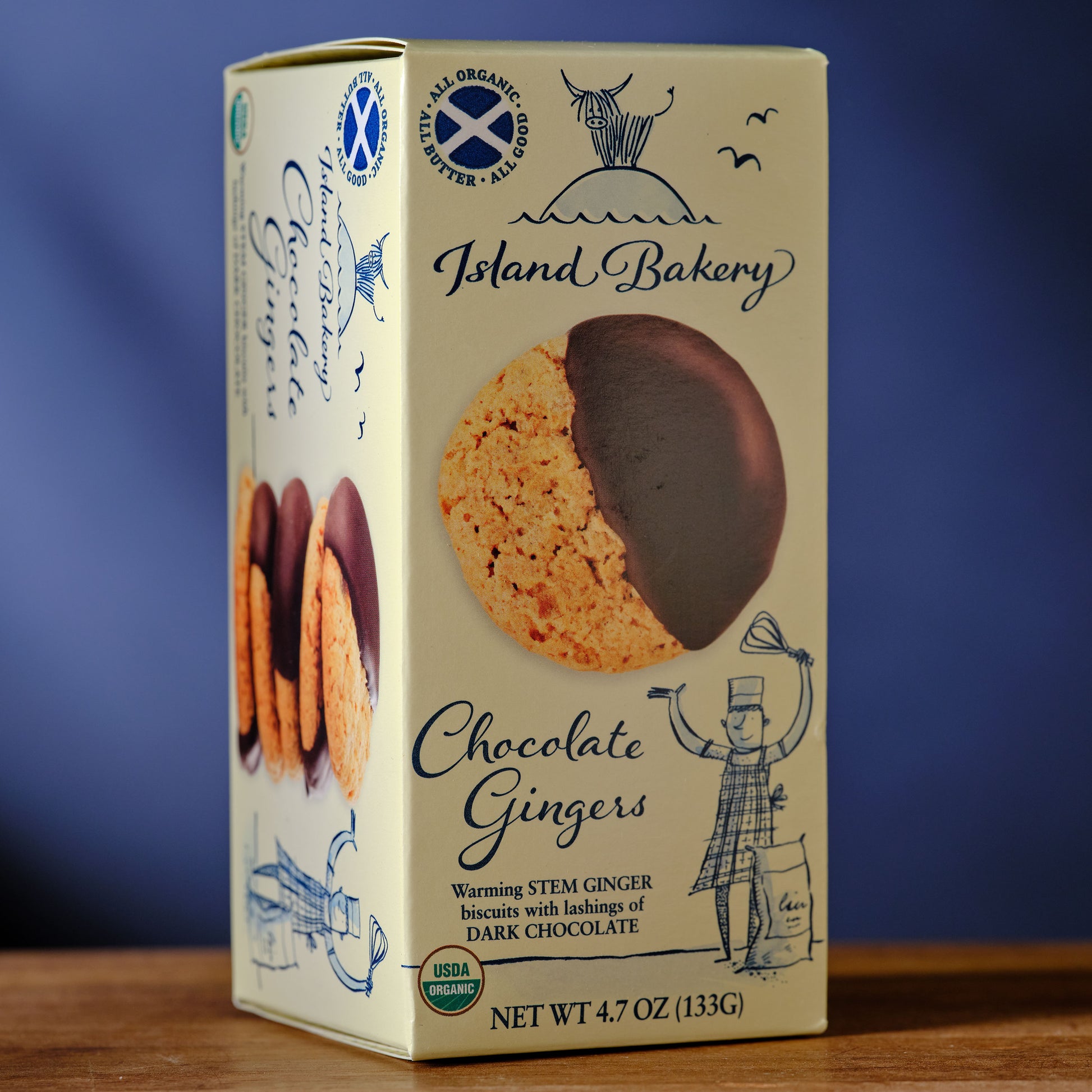 Box of Island Bakery Chocolate Gingers on a wooden surface with a blue background