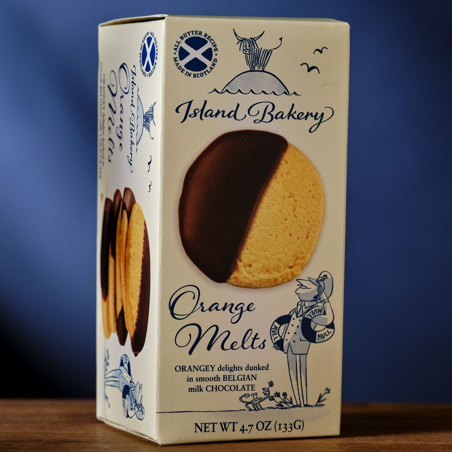 Box of Island Bakery Orange Melts cookies with a blue background Island Bakery Orange Melts Shortbread Cookie with Milk Chocolate