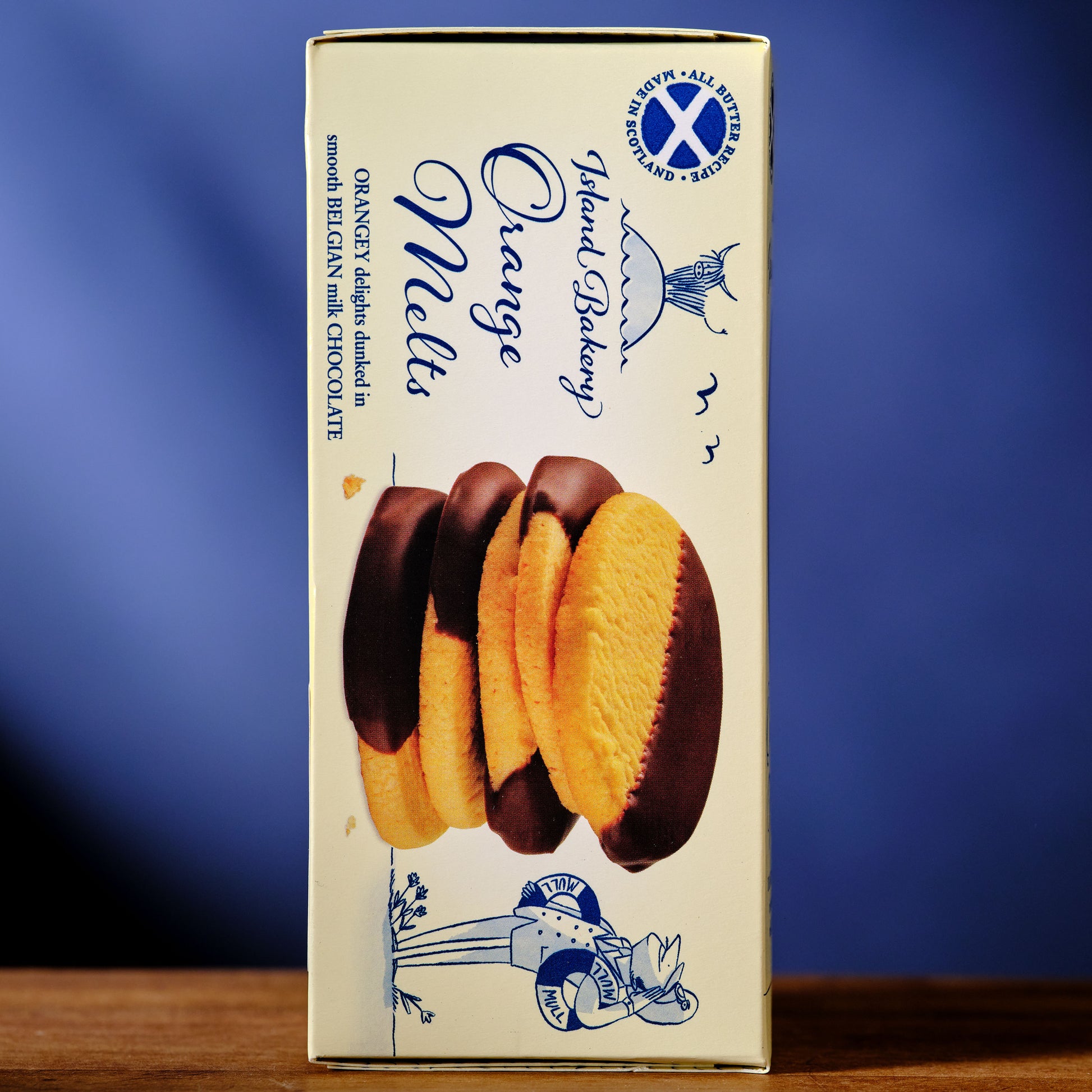 Box of Island Bakery Orange Melts with a blue gradient background Island Bakery Orange Melts Shortbread Cookie with Milk Chocolate