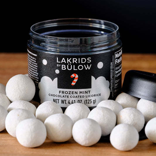 Jar of Lakrids by Bulow frozen mint chocolate coated licorice on a wooden surface.