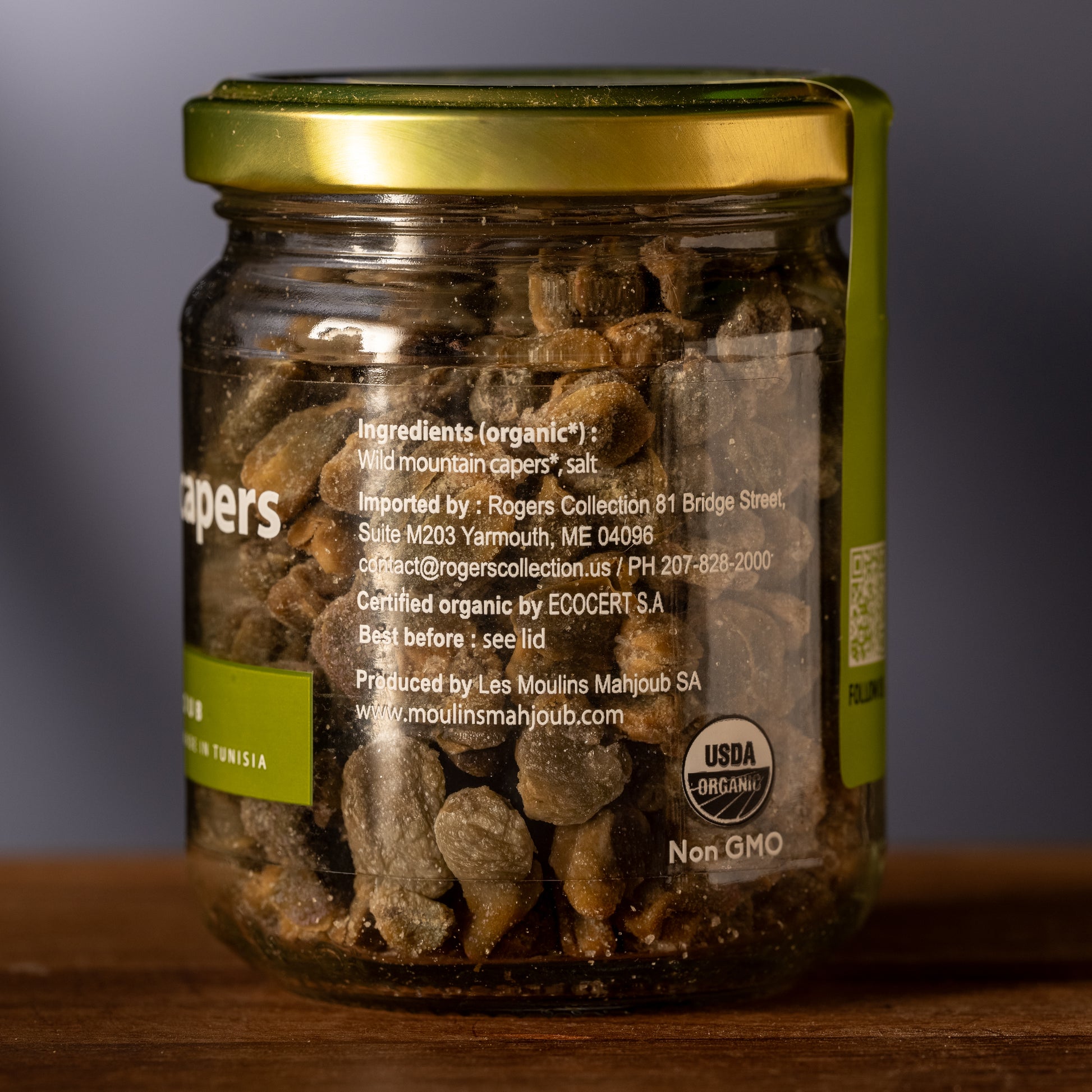 Jar of capers with a visible label on a wooden surface