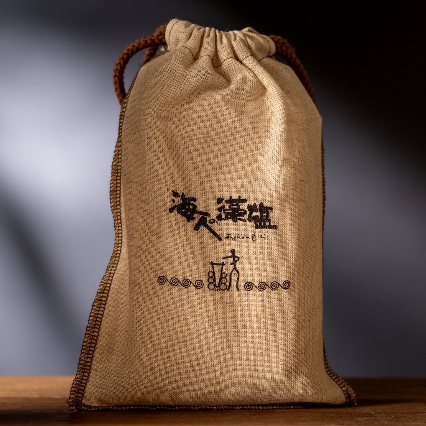 Burlap bag with Japanese writing on it sitting on wood