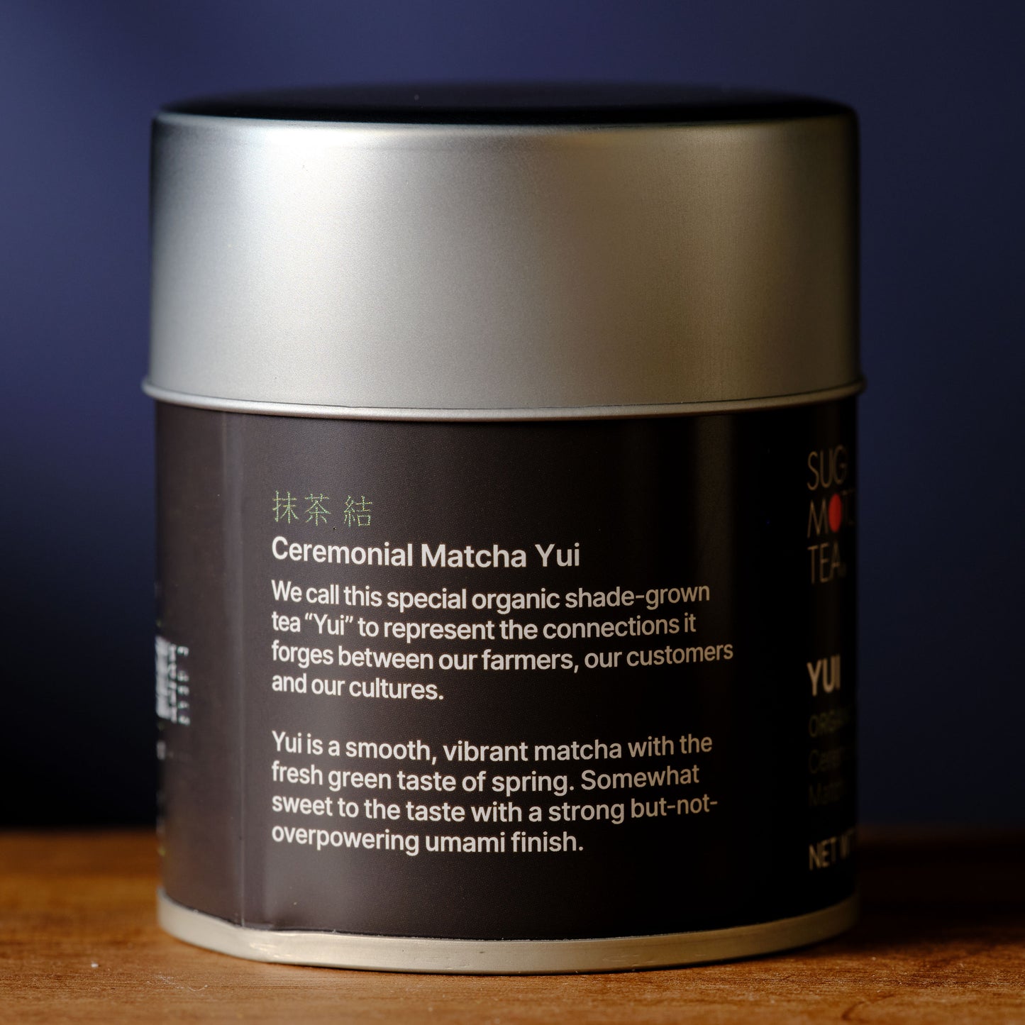 Ceremonial Matcha Yui tea canister with text on a wooden surface