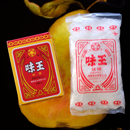 Two packages of 'Wei Wang' seasoning on a dark background Ve Wong MSG - Monosodium L-glutamate